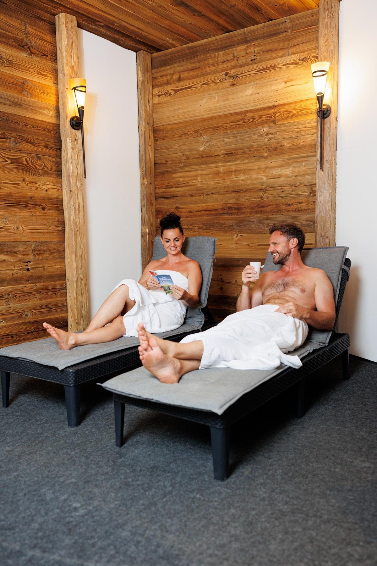 Gäste auf Liegebänken im Wellnessbereich